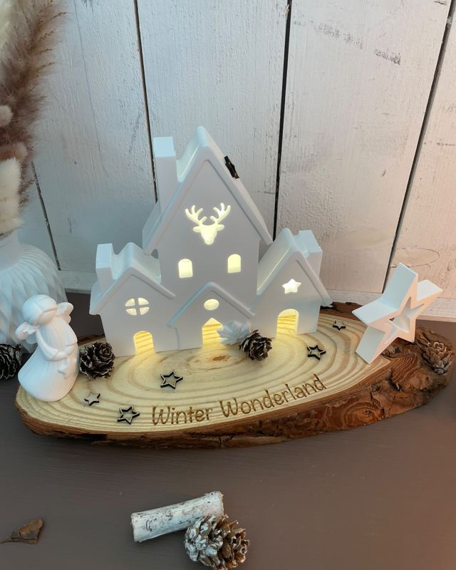 Winter Wonderland auf Baumscheibe mit leuchtendem Gießpulver-Häuschen
